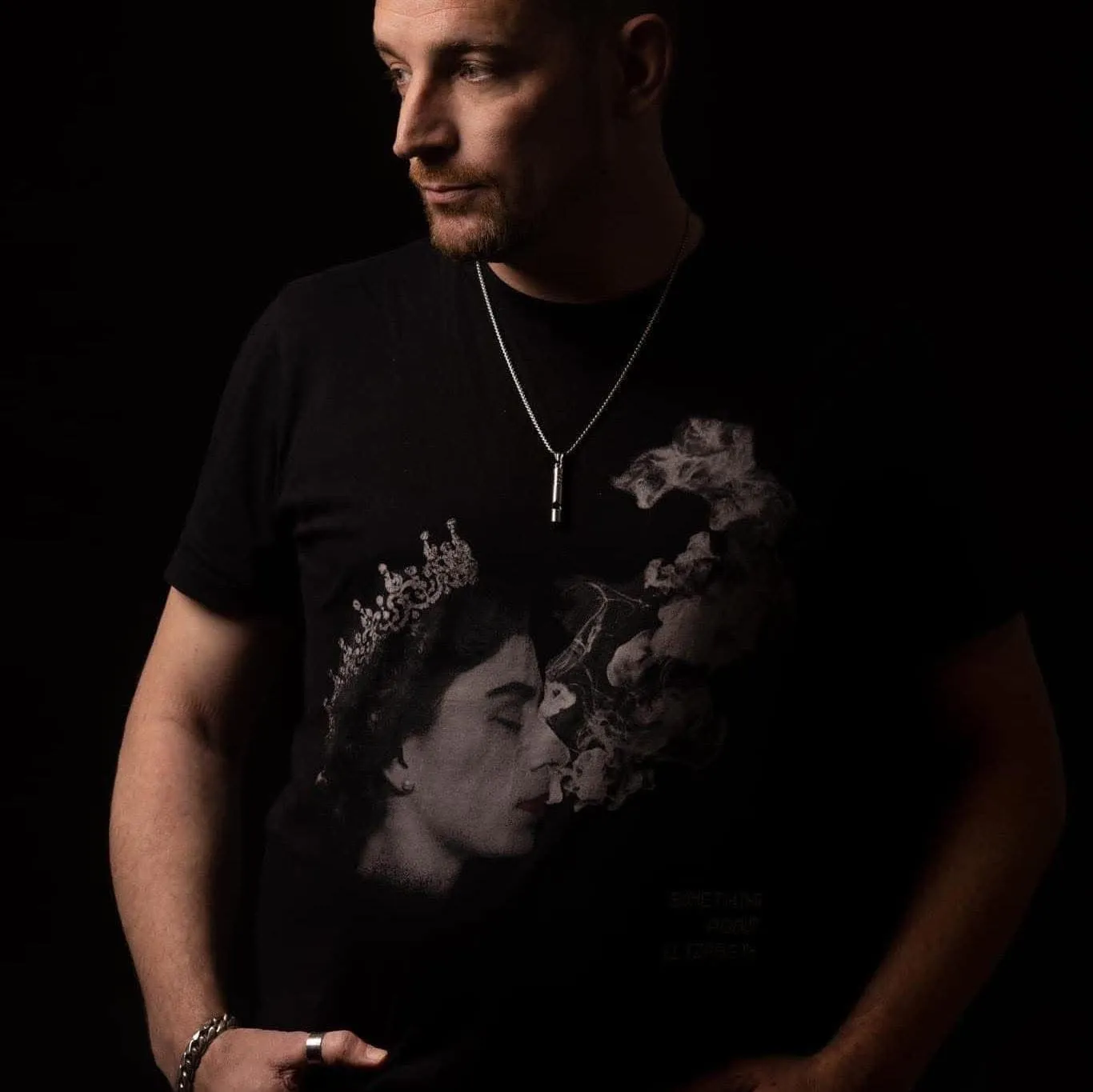 Carl Nicholson in a black graphic T-shirt against a dark background