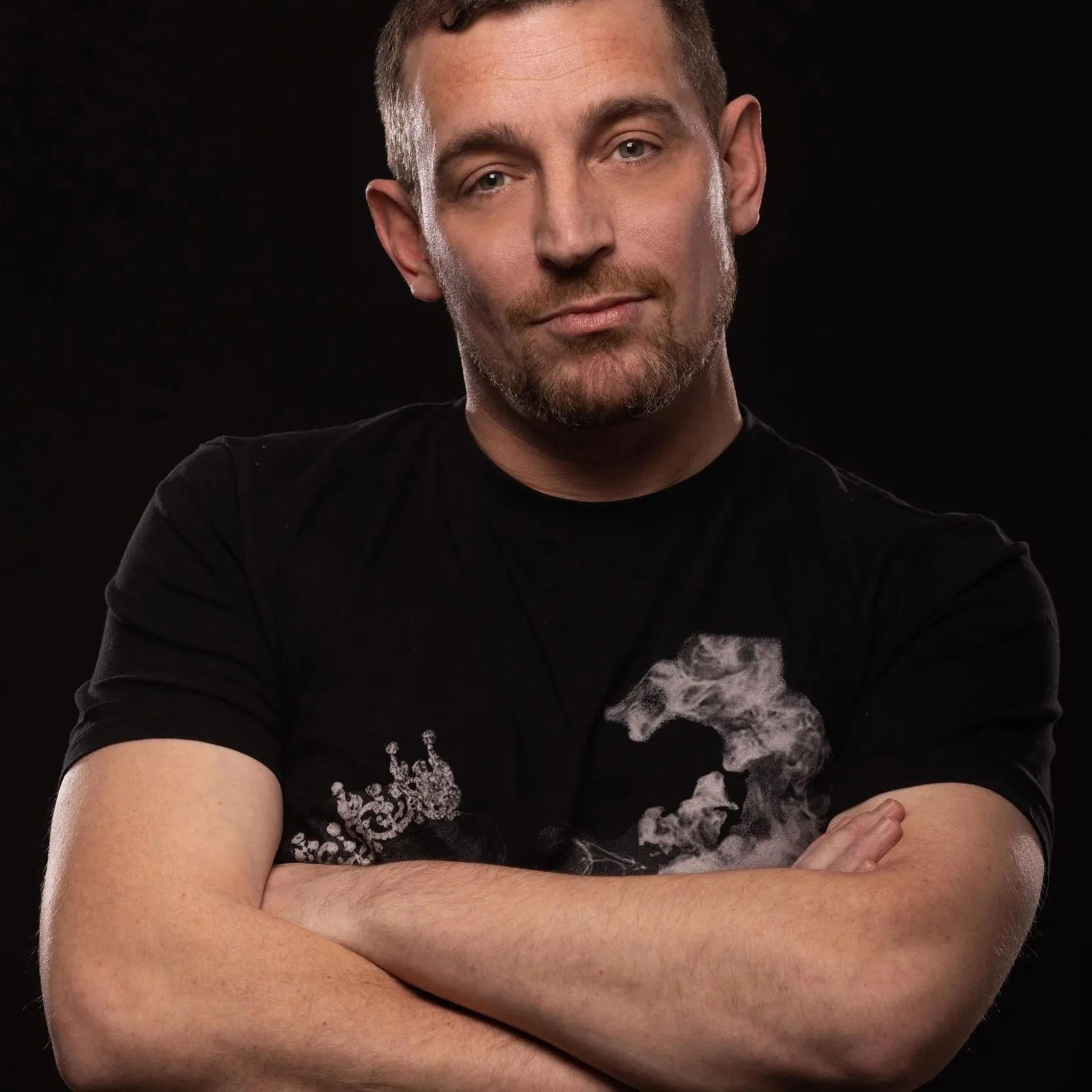 Carl Nicholson in a black T-shirt with his arms crossed